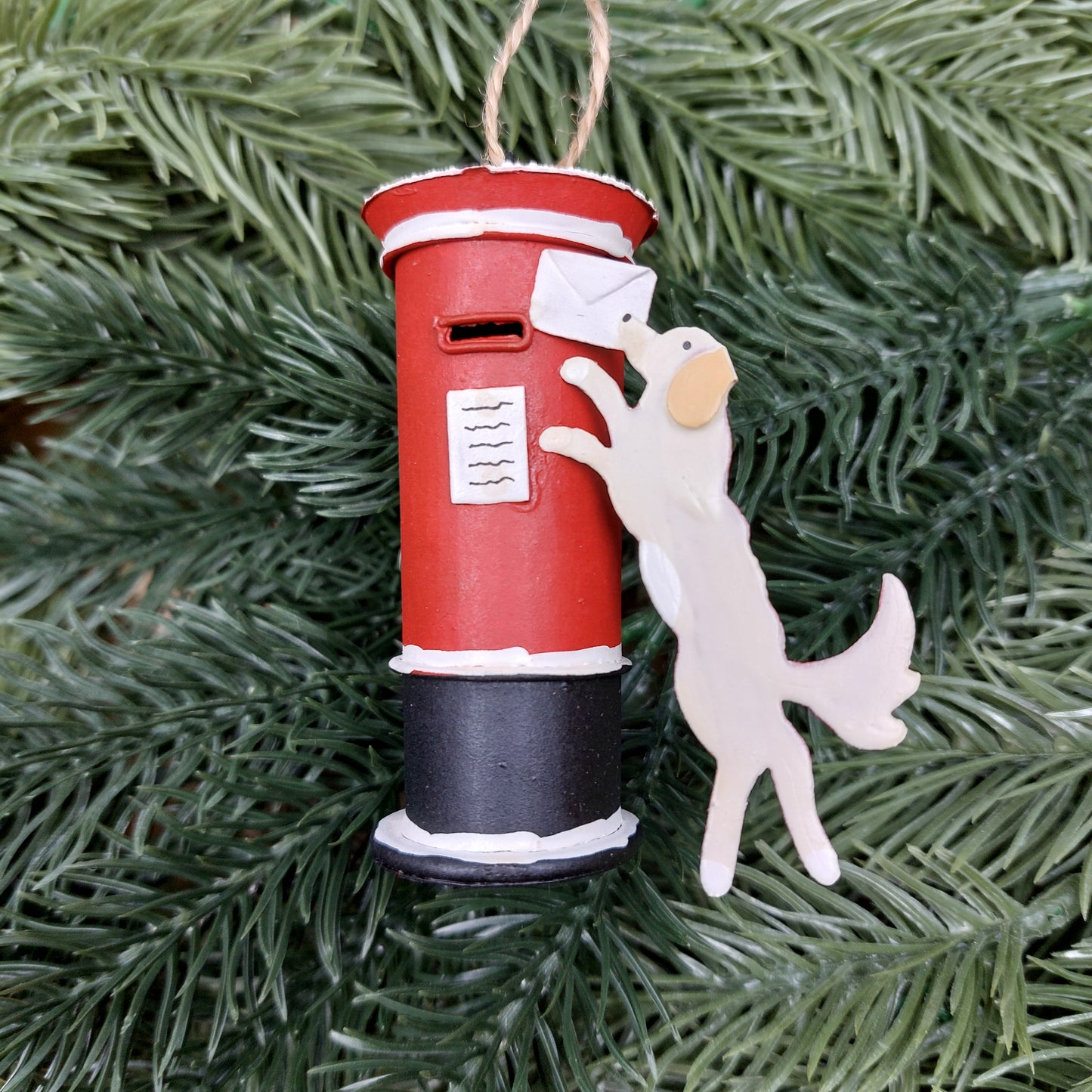 Hanging letterbox and dog ornament against a Christmas tree