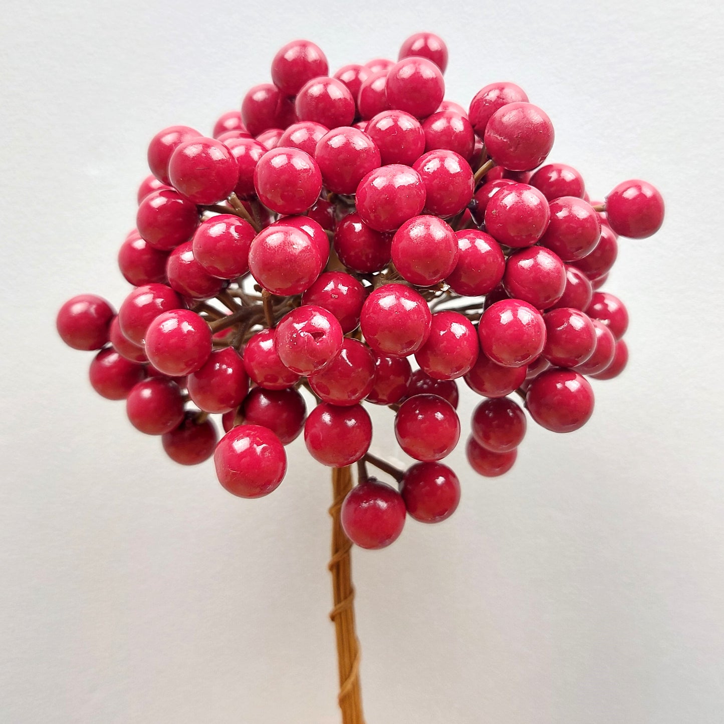 Bouquet of artificial red berries on a white background