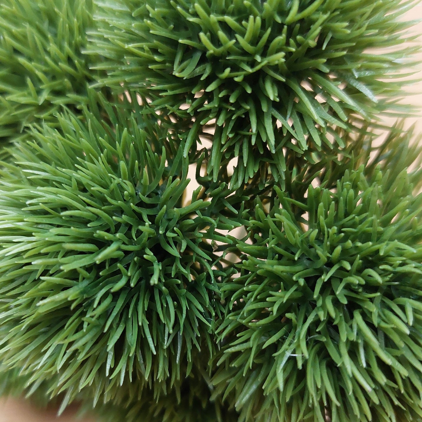 Close-up of green artificial Dianthus plants with a blurred wooden background