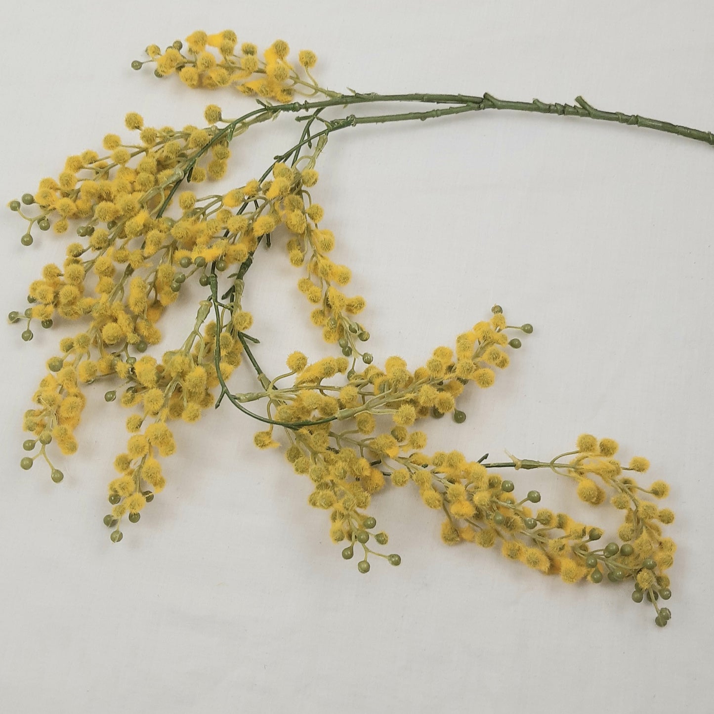 An artificial trailing Mimosa plant, with realistic yellow flowers against a pale background.