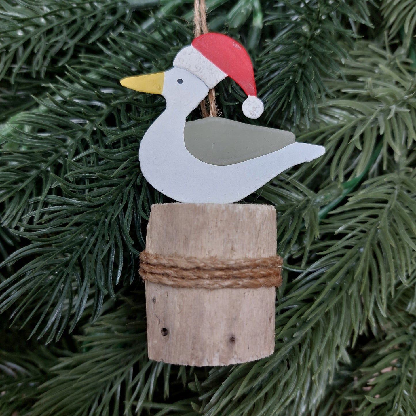 Metal seagull with a wooden base on a Christmas tree.