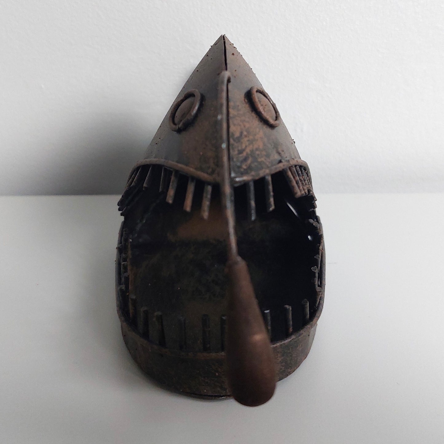 Decorative metal angler fish object on a white background