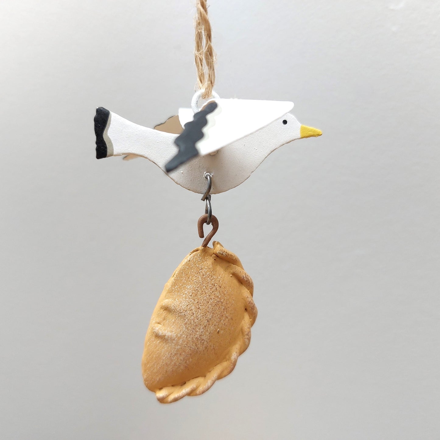 Decorative ornament of a seagull with a pastry on a gray background
