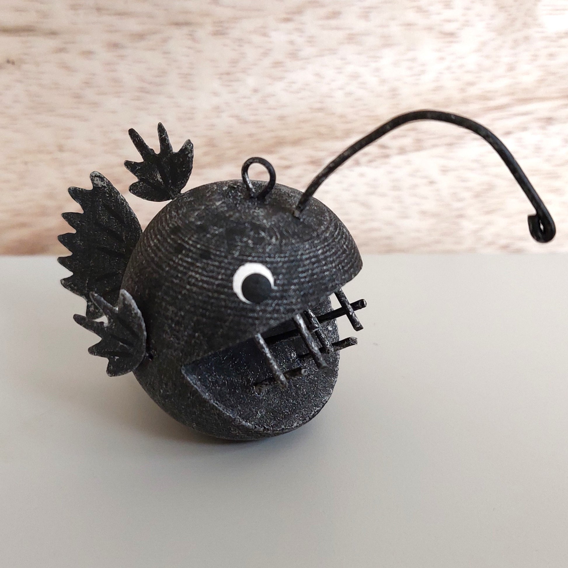 Black metal and wooden ornament on a light wooden surface