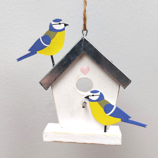 Decorative birdhouse wooden hanging decoration with painted birds on a plain background