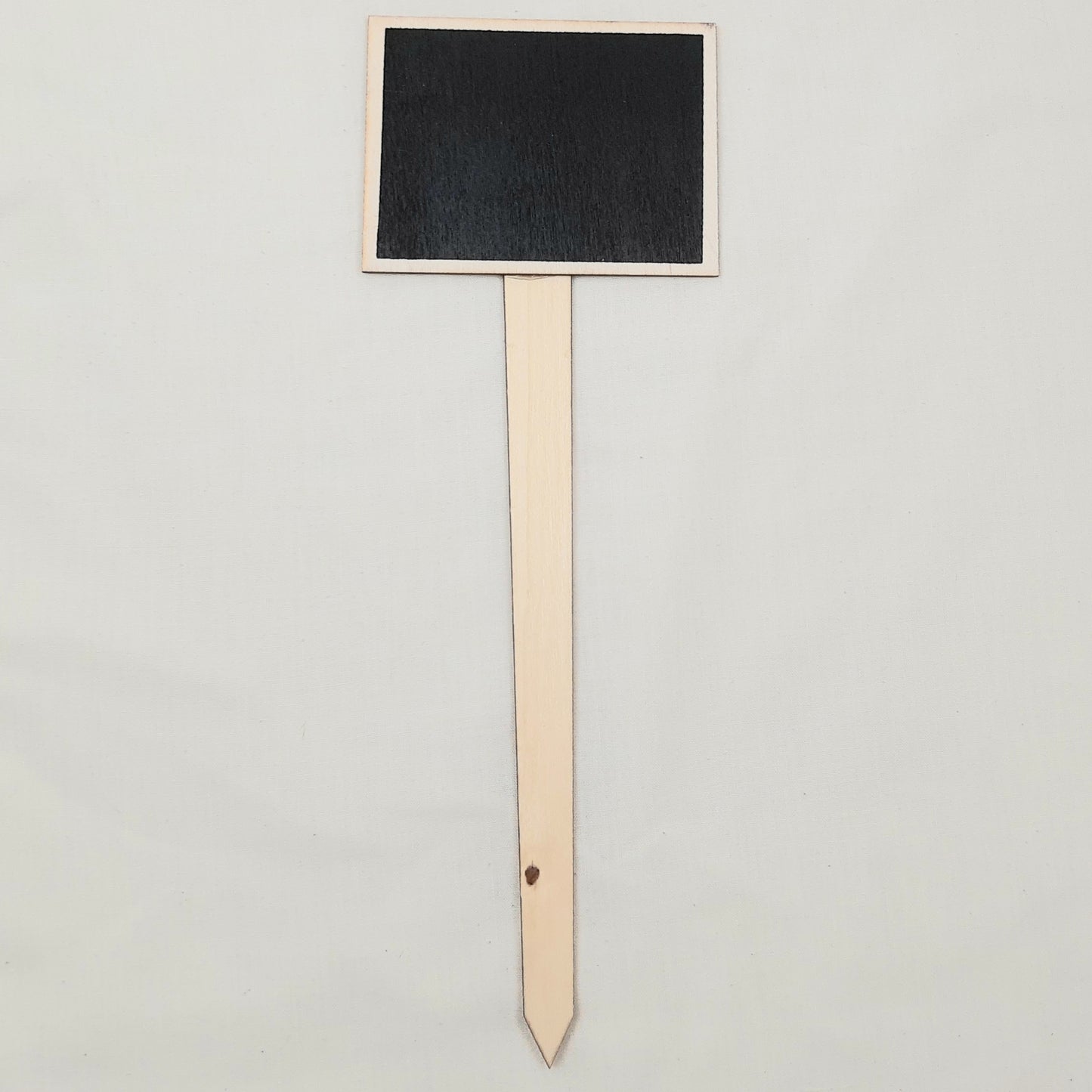 Black rectangular chalkboard sign on a wooden stand against a light gray background