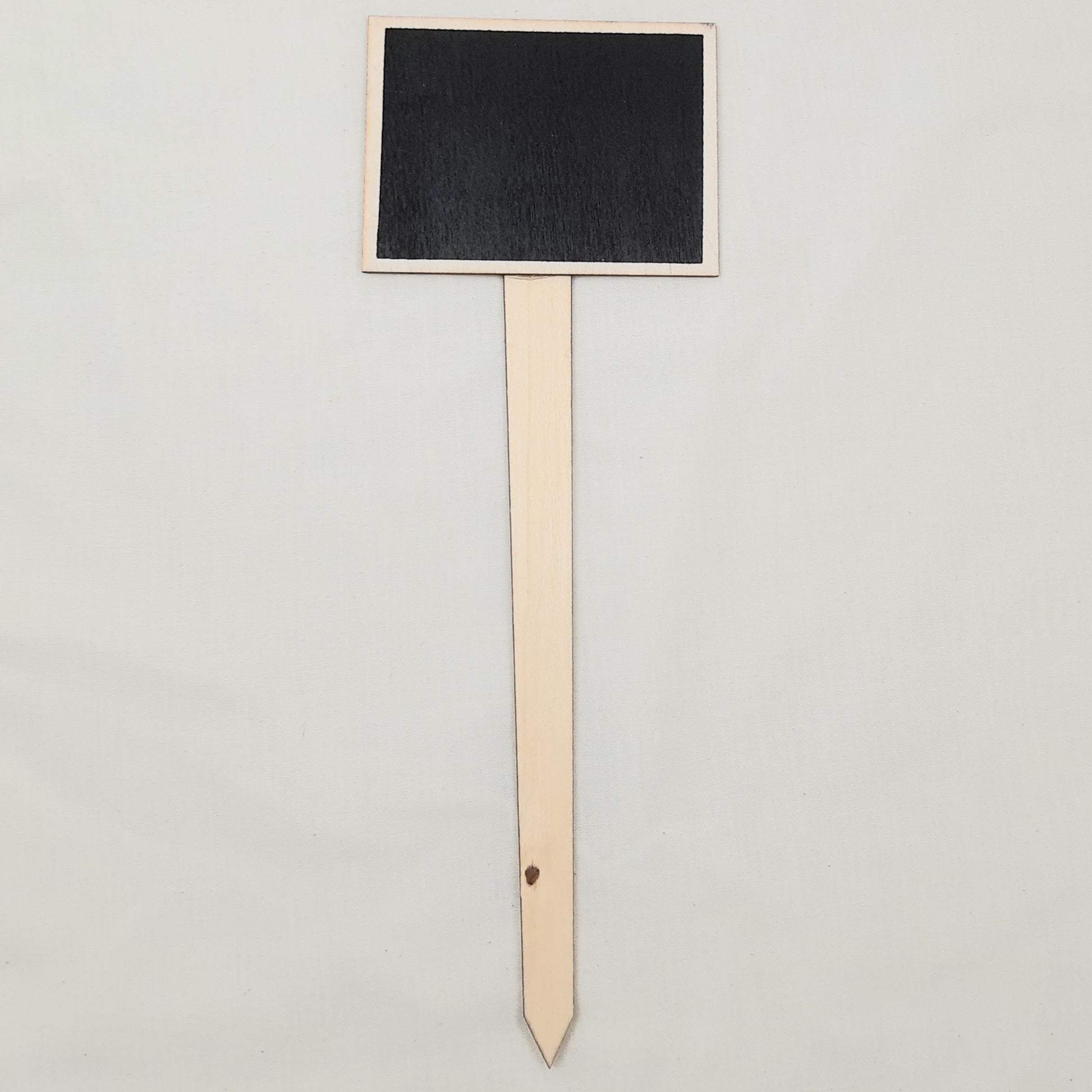 Black rectangular chalkboard sign on a wooden stand against a light gray background