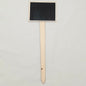 Black rectangular chalkboard sign on a wooden stand against a light gray background
