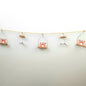 Decorative string with crab and fish ornaments on a plain background