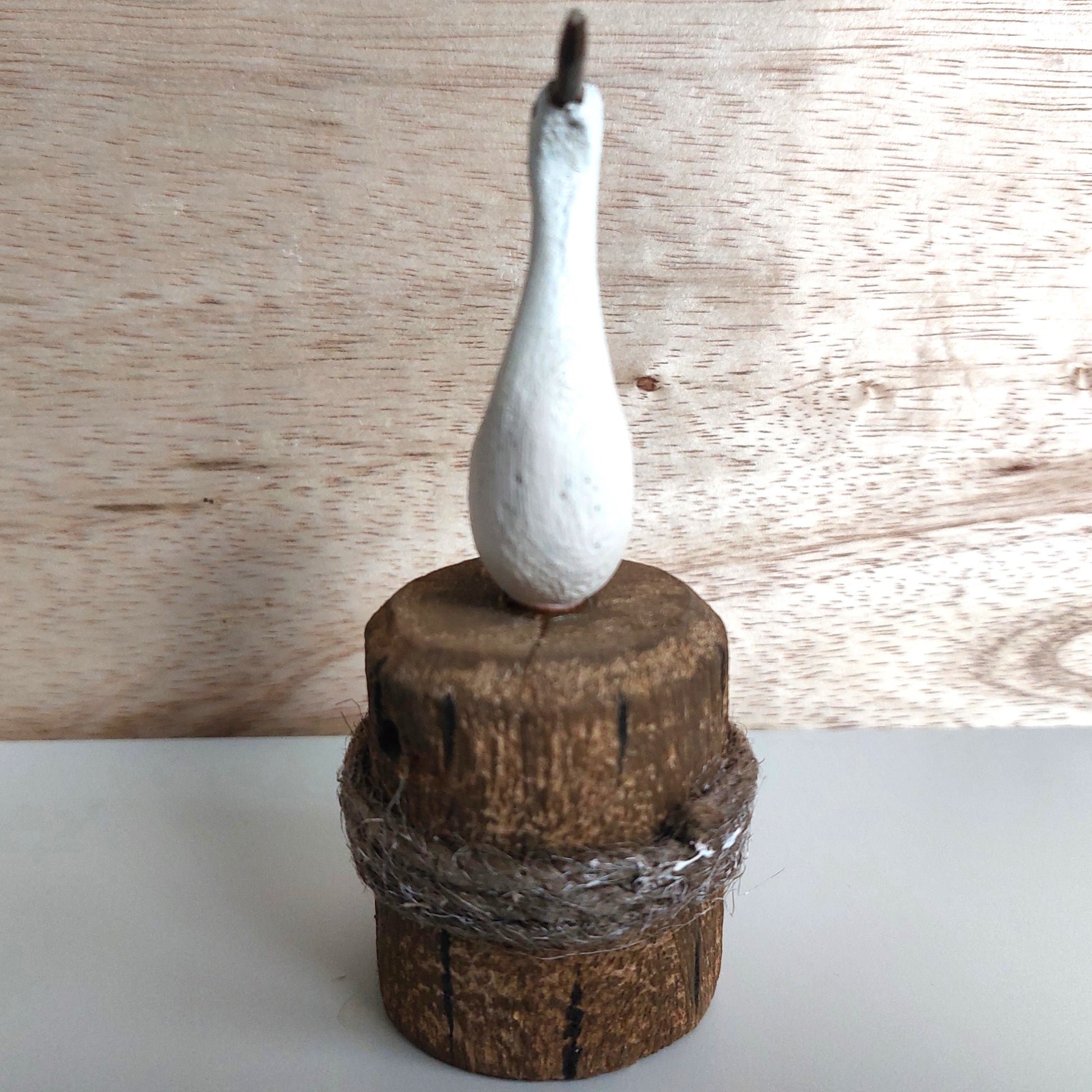 Decorative bird figure on a wooden base against a wooden background
