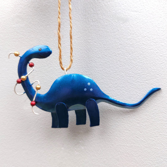 Blue dinosaur ornament hanging on a white background