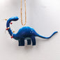 Blue dinosaur ornament hanging on a white background