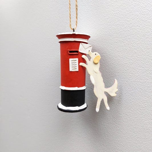 Hanging letterbox with a dog holding a letter ornament against a pale background