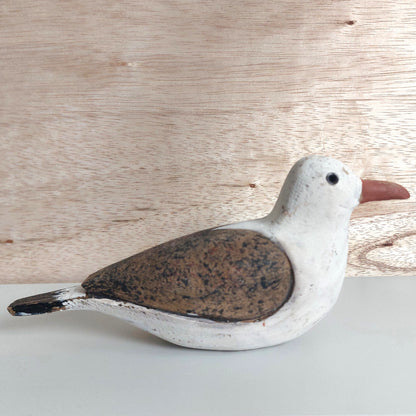 Decorative wooden hand painted seagull figurine on a wooden surface