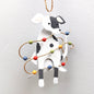 A tin spotty dog decoration with Christmas lights against a white background