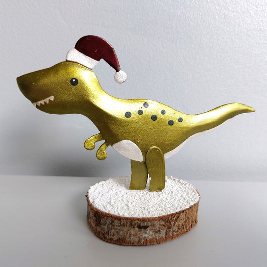A metal T-Rex wearing a santa hat on a wooden base
