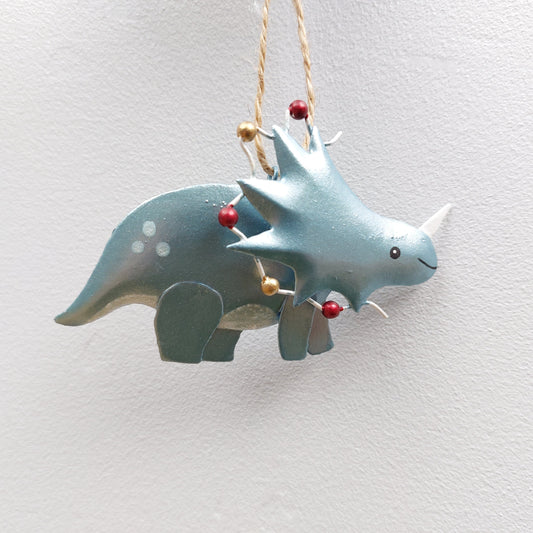 Decorative green dinosaur ornament with Christmas lights on a white background