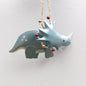 Decorative green dinosaur ornament with Christmas lights on a white background