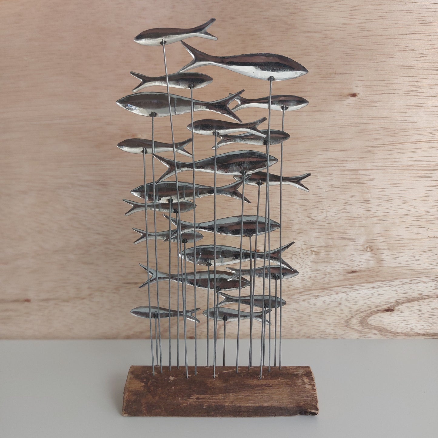 Metal fish wall art on a wooden board