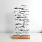 Decorative sculpture of fish on a wooden base against a white background