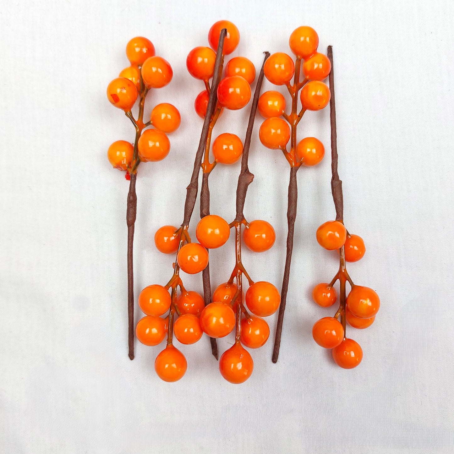 A pack of 6 faux orange berry picks, on a white background