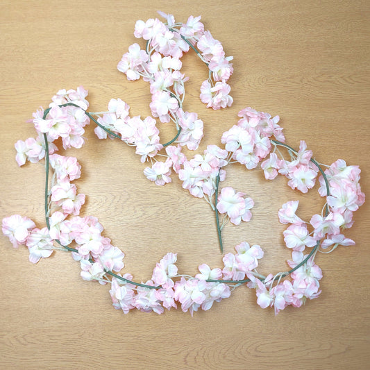 Floral Pink and white artificial Cherry Blossom Garland on a wooden surface