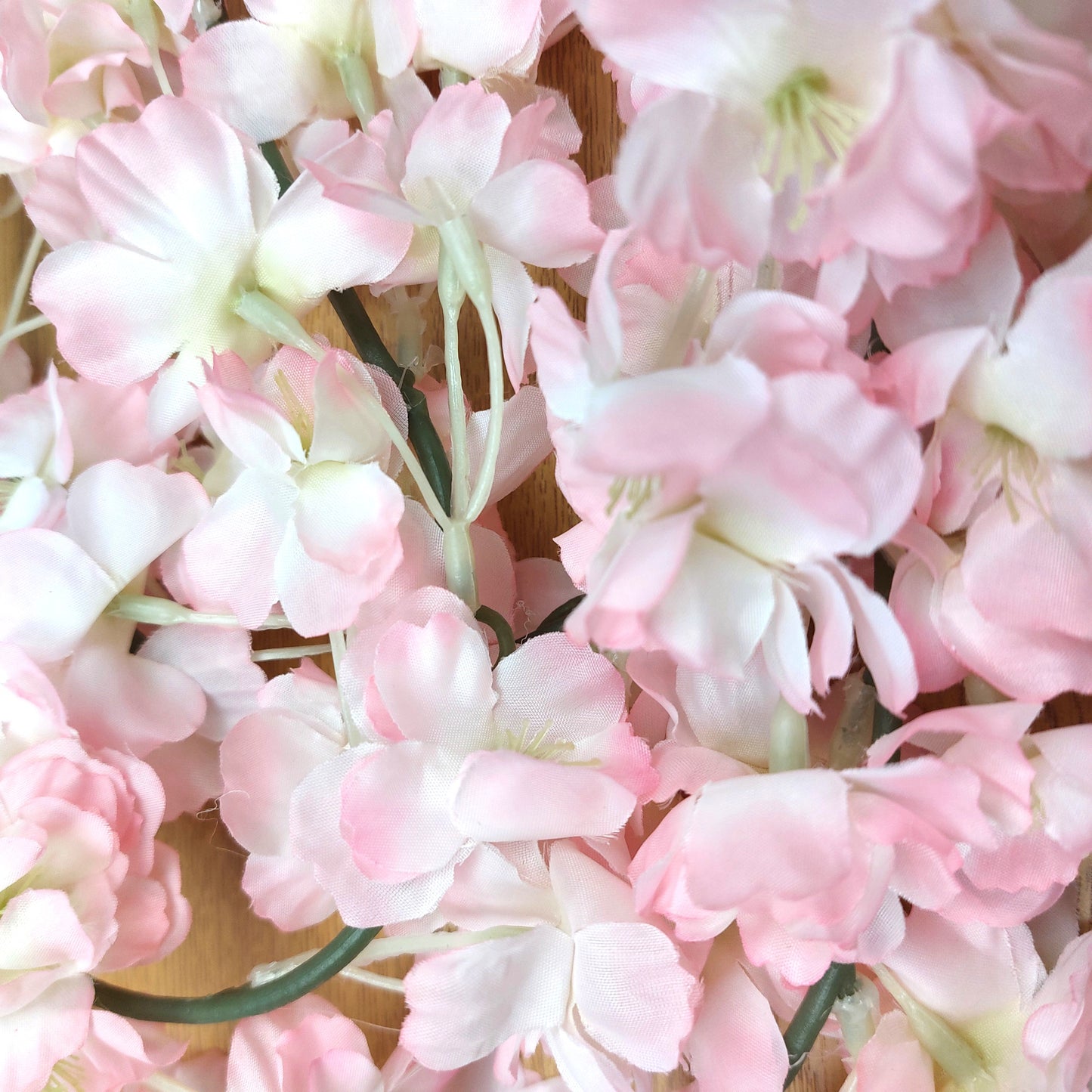 Close-up of pink and white artificial Cherry Blossom flowers on a wooden surface
