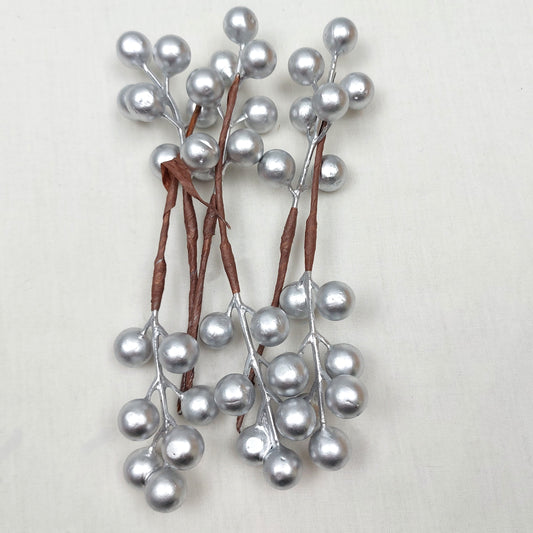 Artificial Silver Berries on picks against a white background