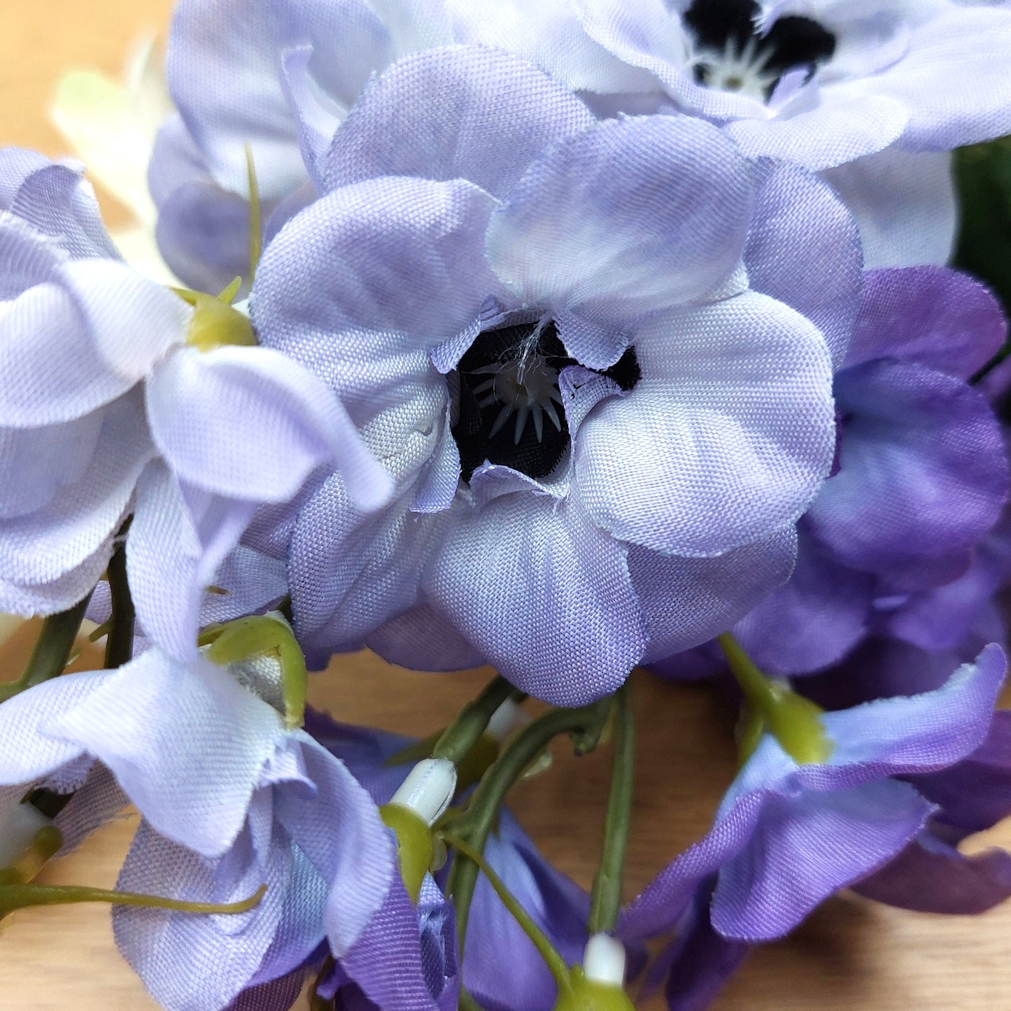 Close-up of purple flowers with green stems on a wooden surface