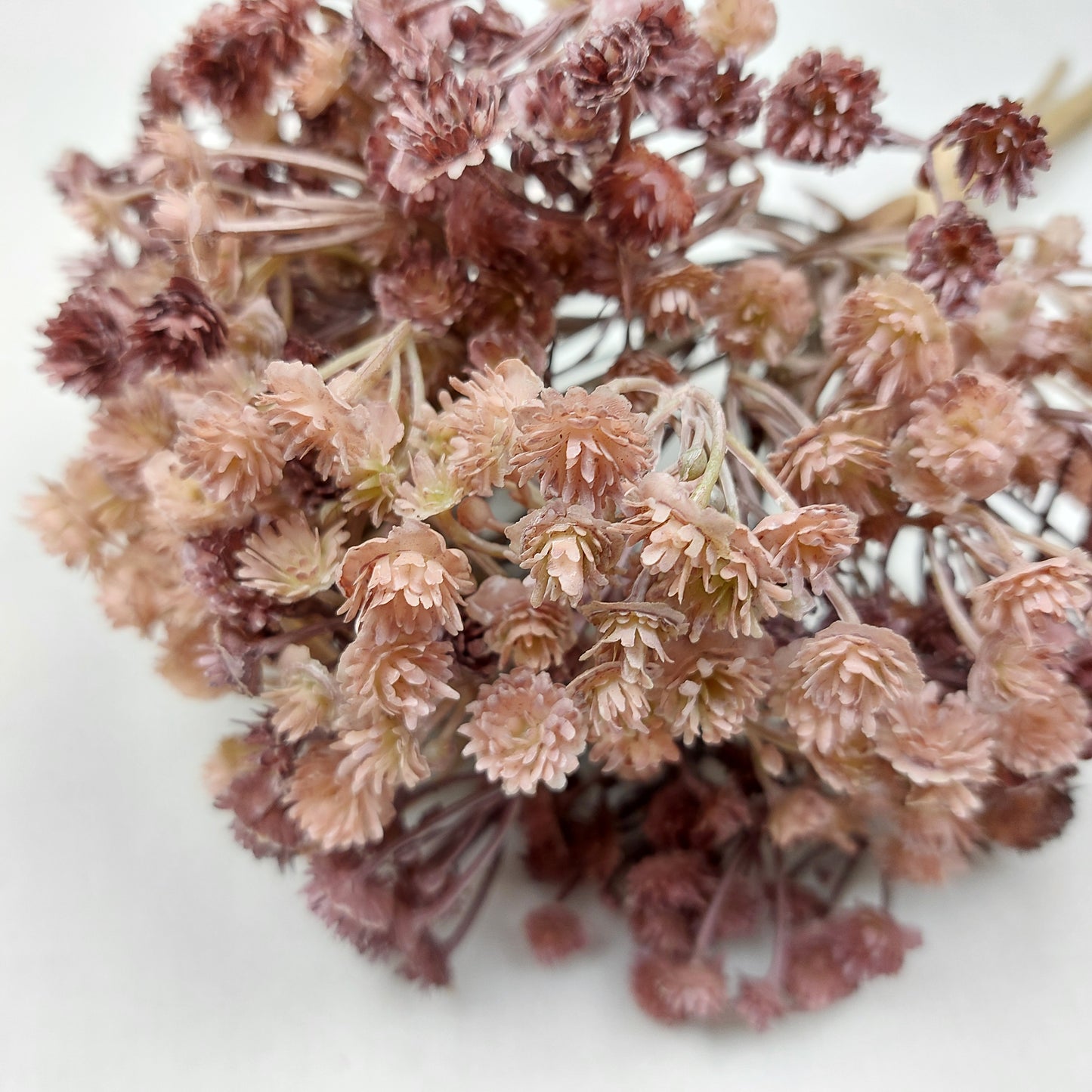 Artificial Bouquet of dried look flowers in shades of pink and purple on a white background
