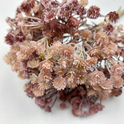 Artificial Bouquet of dried look flowers in shades of pink and purple on a white background