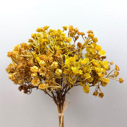 Artificial Bouquet of dried look yellow flowers on a light gray background