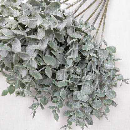 Close up of artificial Eucalyptus greenery against a white background