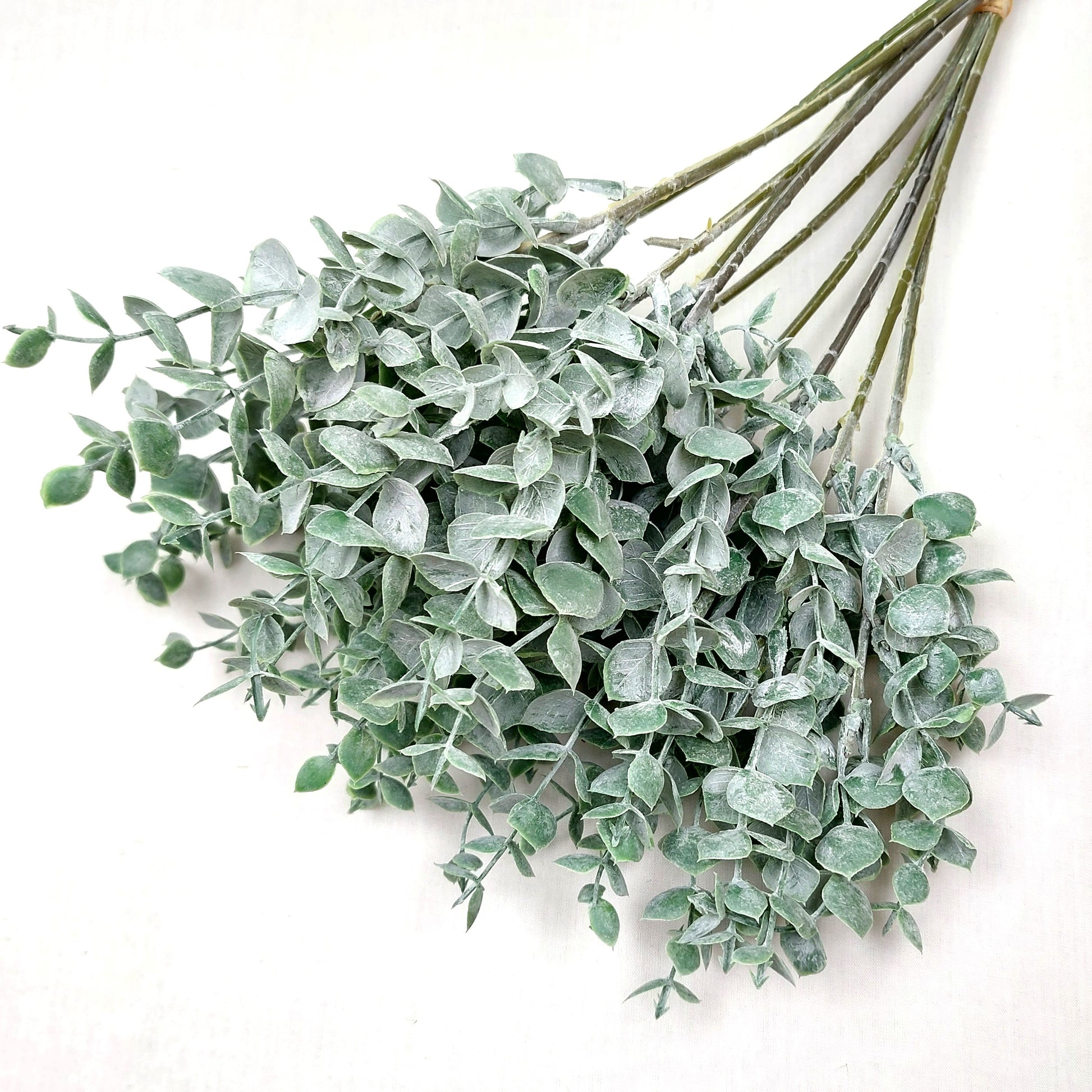 Artificial Green Eucalyptus Springs against a white background 
