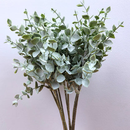 Artificial Green Eucalyptus against a grey background 