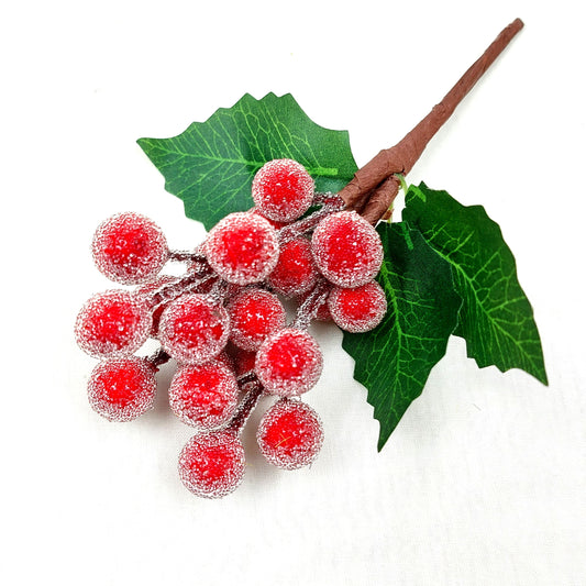 Artificial leafy berry branch with red berries and green leaves on a white background