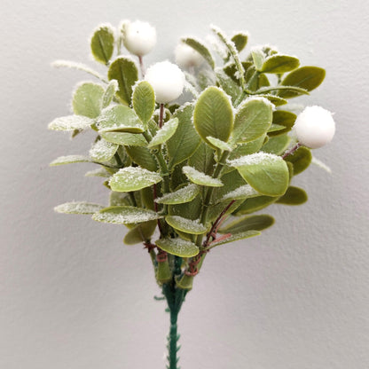 Artificial green leaf Mistletoe branch with white berries on a plain background