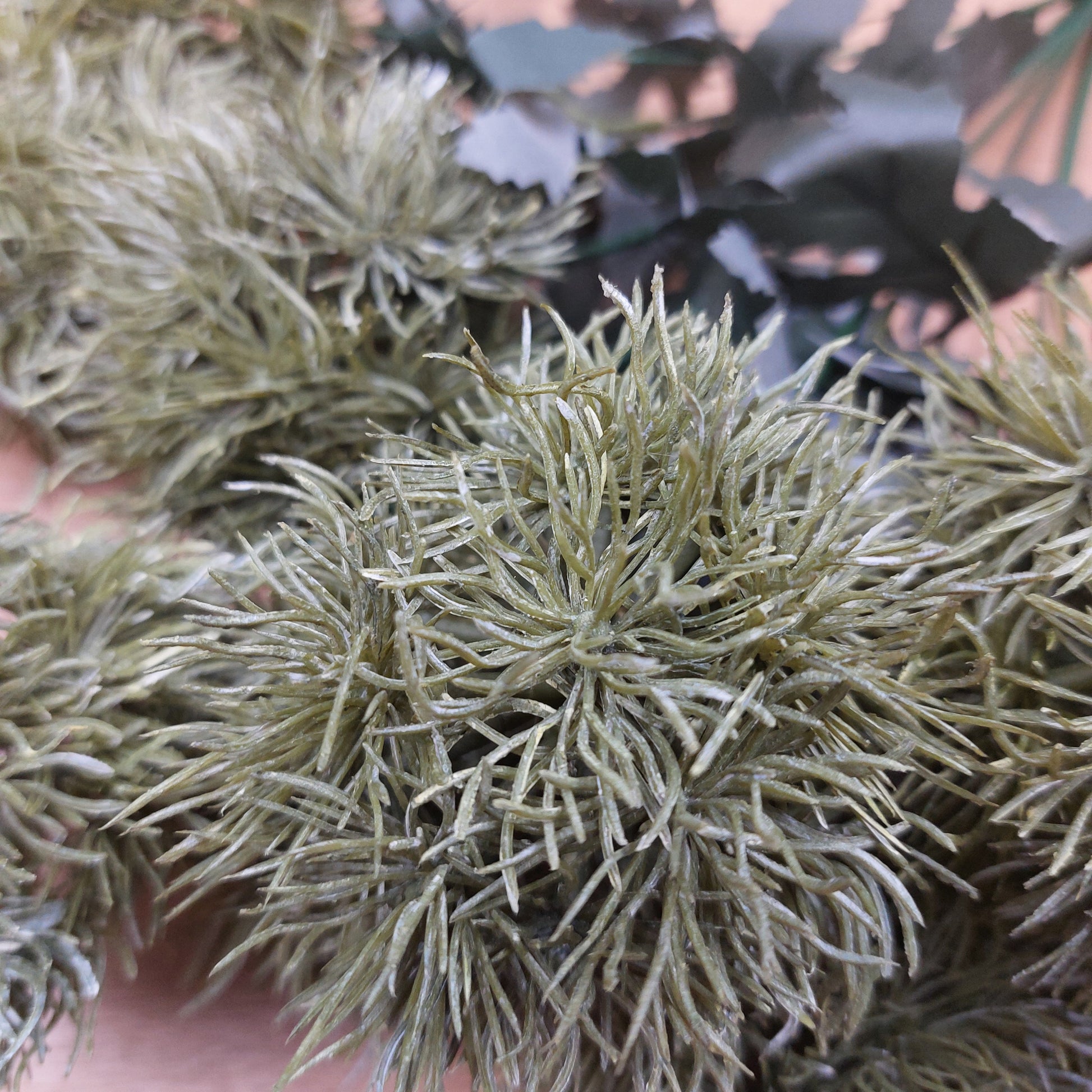 Close-up of an artificial Green Trick textured plant laying on a wooden background