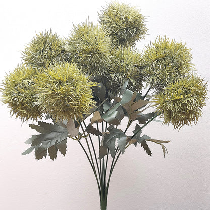 An artificial Green Trick Dianthus Pom Pom bush with foliage against a pale background