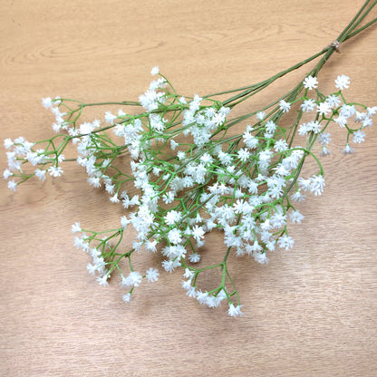 A bunch of artificial White Gypsophila against a wooden background