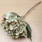 Artificial hydrangea flower branch on a wooden surface