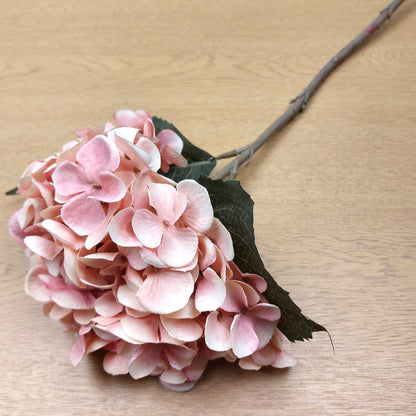 Artificial Pink hydrangea flower on a wooden surface