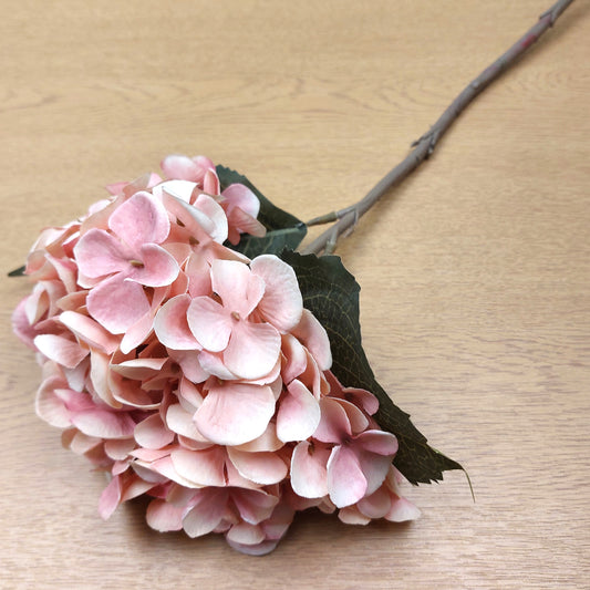 Artificial Pink hydrangea flower on a wooden surface