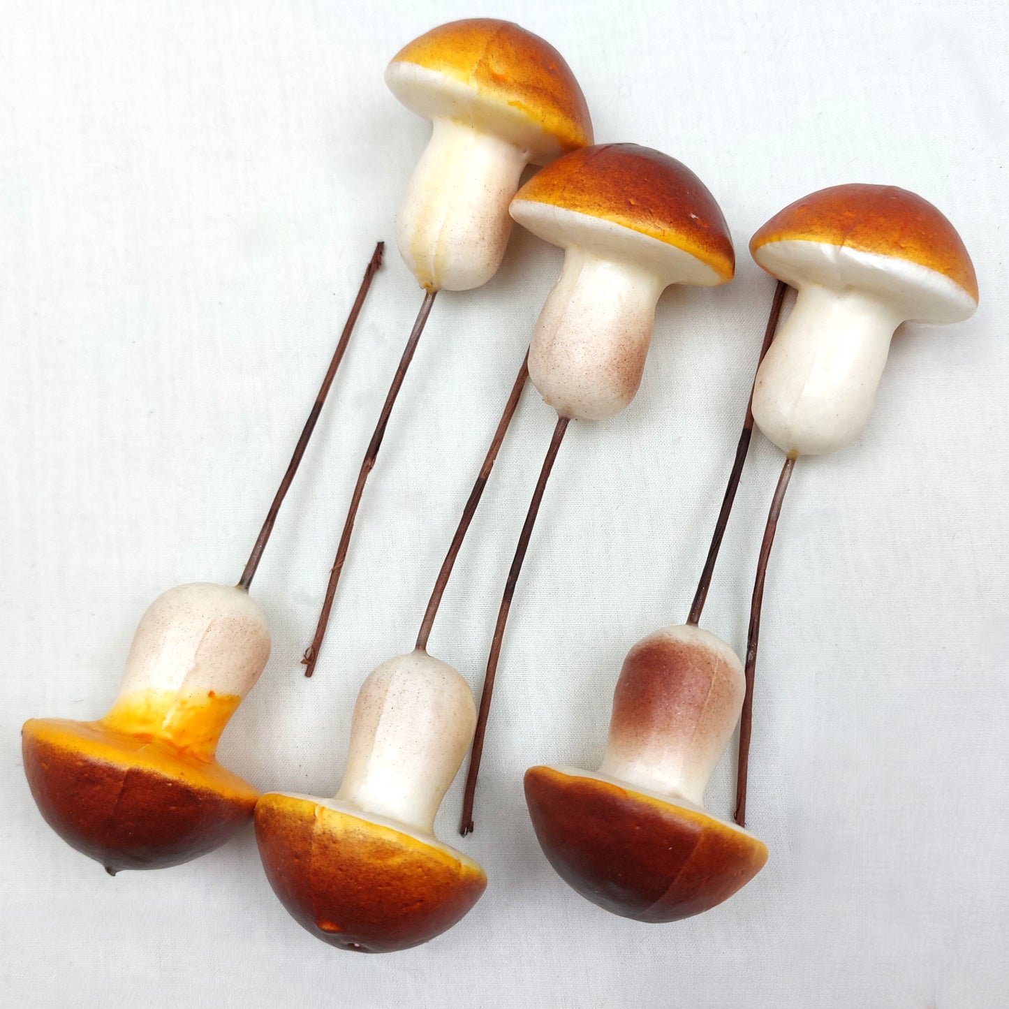 Artificial Brown Mushrooms on picks against a white background