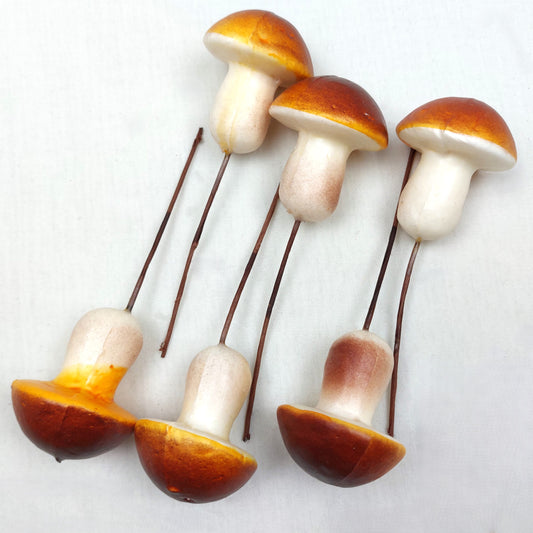 Artificial Brown Mushrooms on picks against a white background