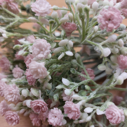 A close up of artificial pastel pink open Gyp with White Buds