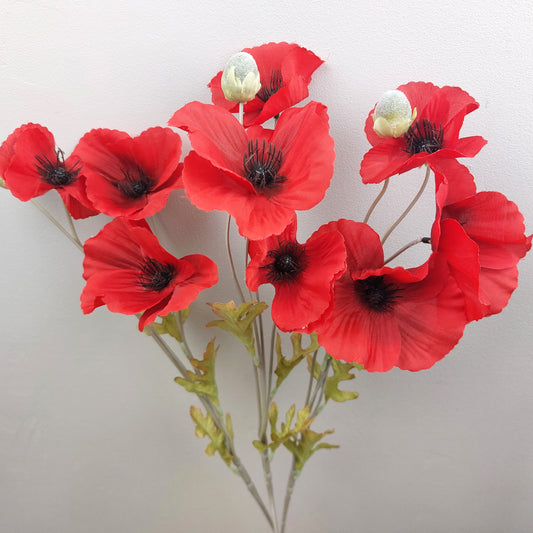 Red artificial poppies on a plain background