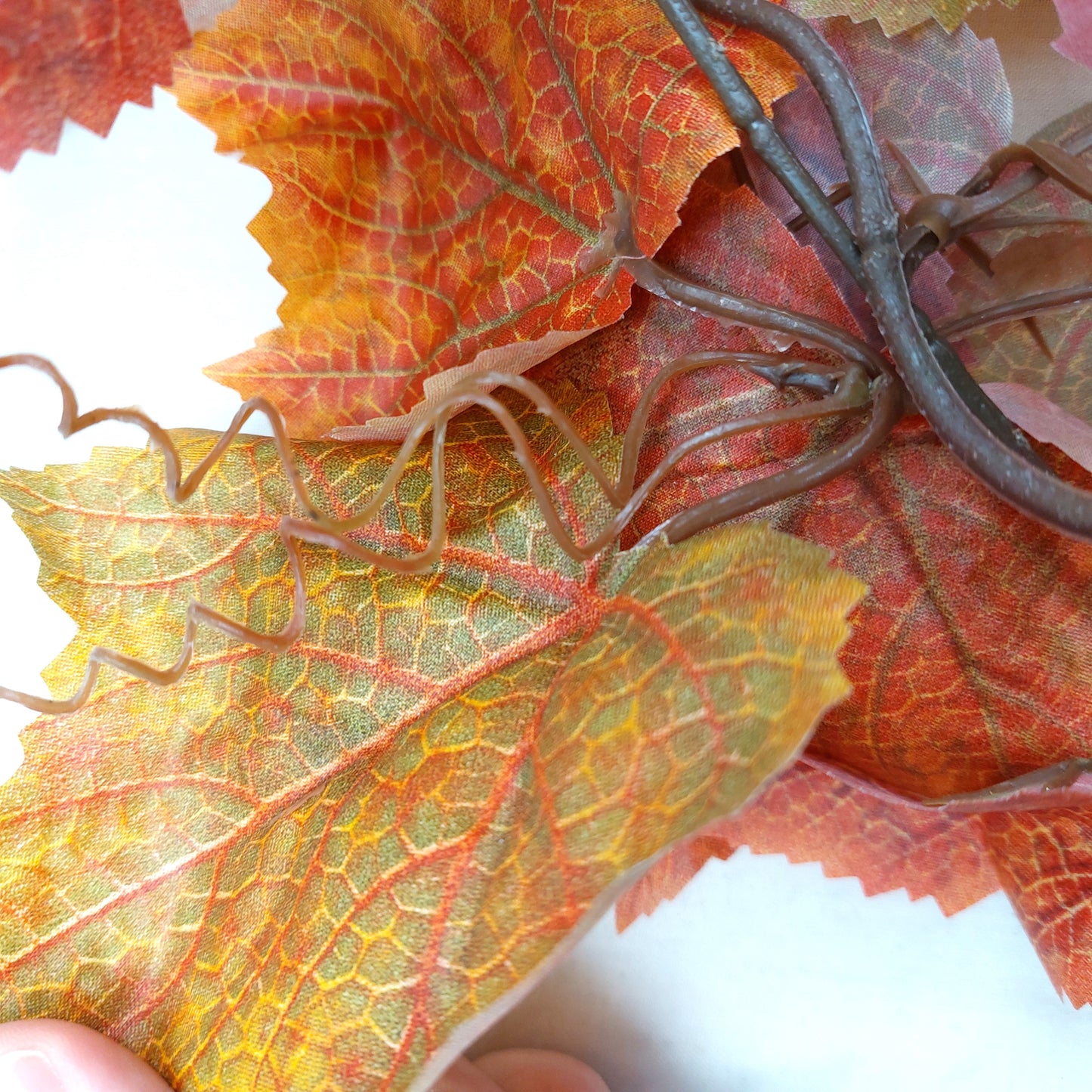 Close-up of faux autumn leafy garland on a white background