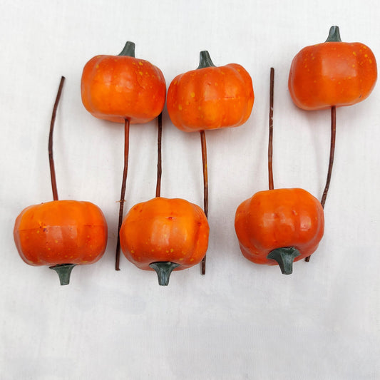 Set of orange decorative pumpkins with stems on a white background