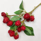 Artificial Red Raspberries with green leaves against a white background
